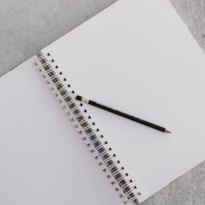 ashley-west-edwards-4XOuAqQSj-Y-unsplash Blank notebook and pencil on a desk