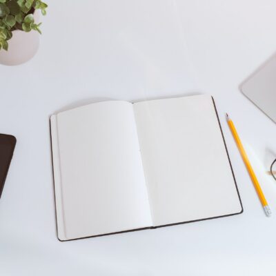 jeshoots-com-pUAM5hPaCRI-unsplash Open notebook and pencil on a desk