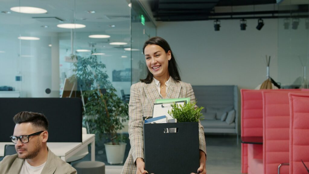 Employee leaving the office with a box of belongings after being fired