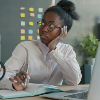 Woman looking away from her laptop at work Woman looking away from her laptop at work