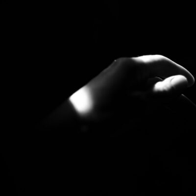 Hand illuminated by a single beam of light