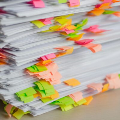 Stacks of claim documents marked with sticky tabs - insurance fraud whistleblower Stacks of claim documents marked with sticky tabs - insurance fraud whistleblower