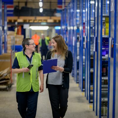 Workers walking through a warehouse aisle Workers walking through a warehouse aisle